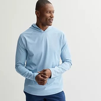 Male model wearing a light blue long-sleeve pullover hoodie with a relaxed fit